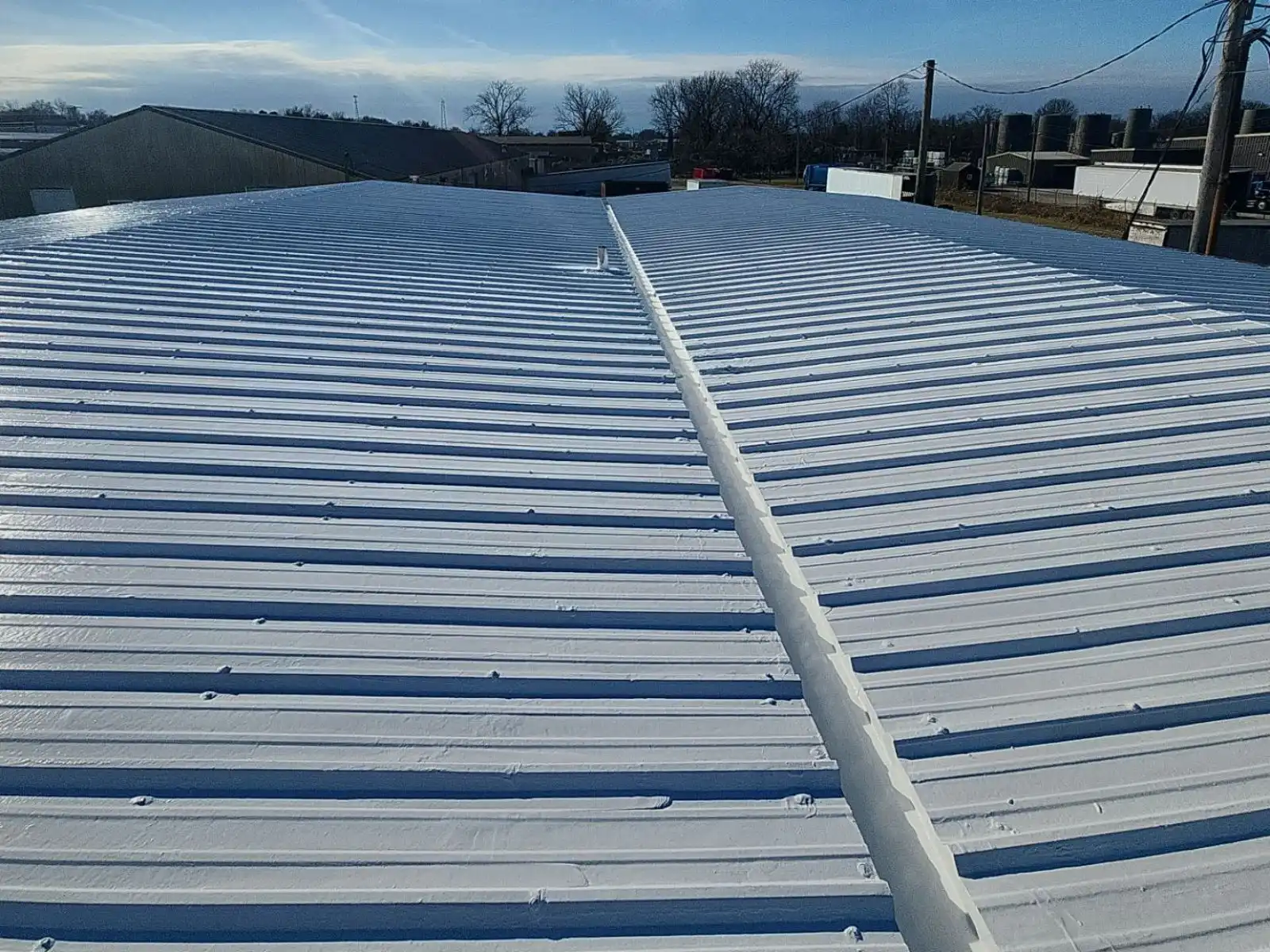 After: metal roof with a seamless white coating, valley sealed