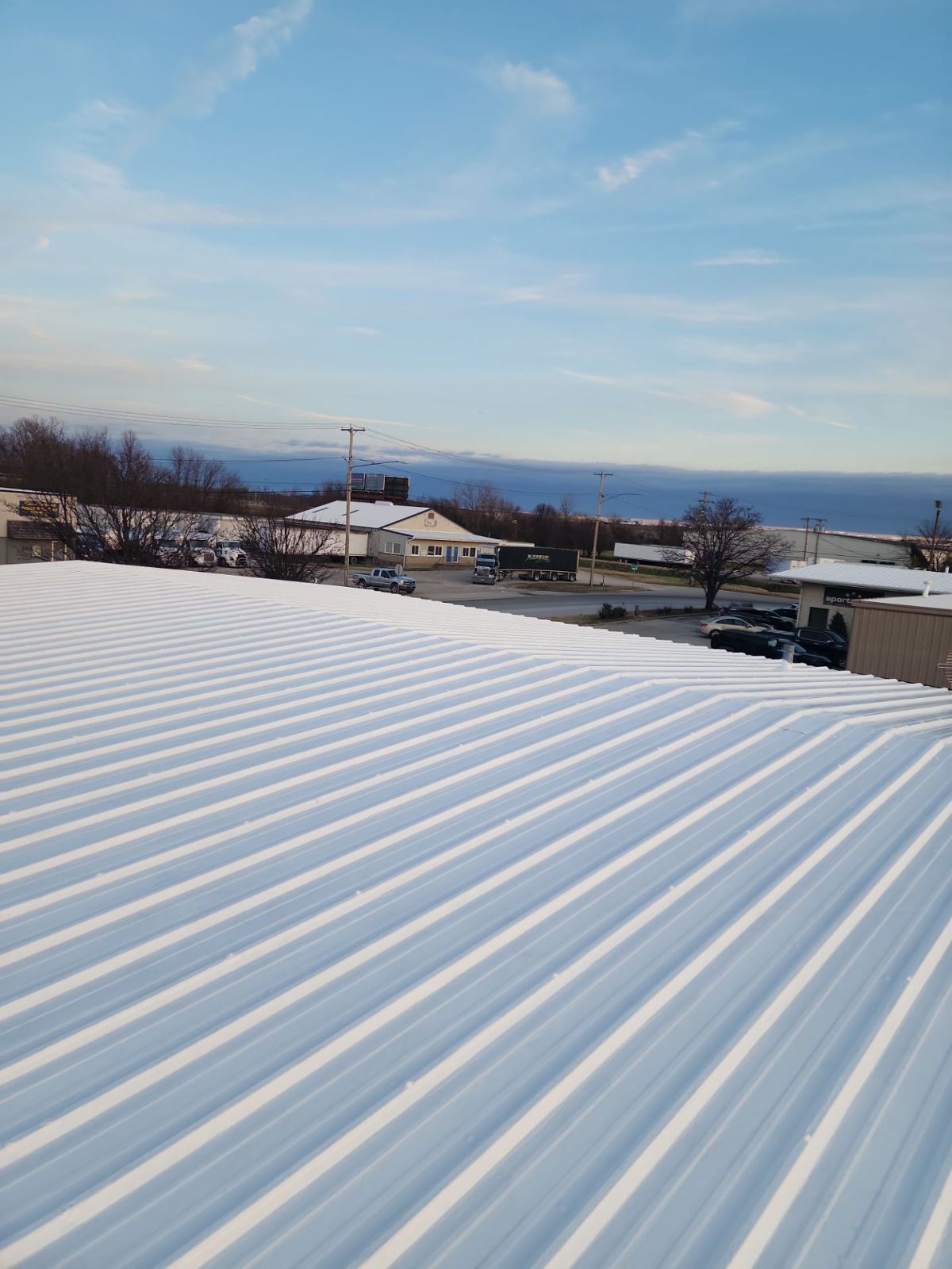 Coated metal roof panels with neighboring commercial buildings