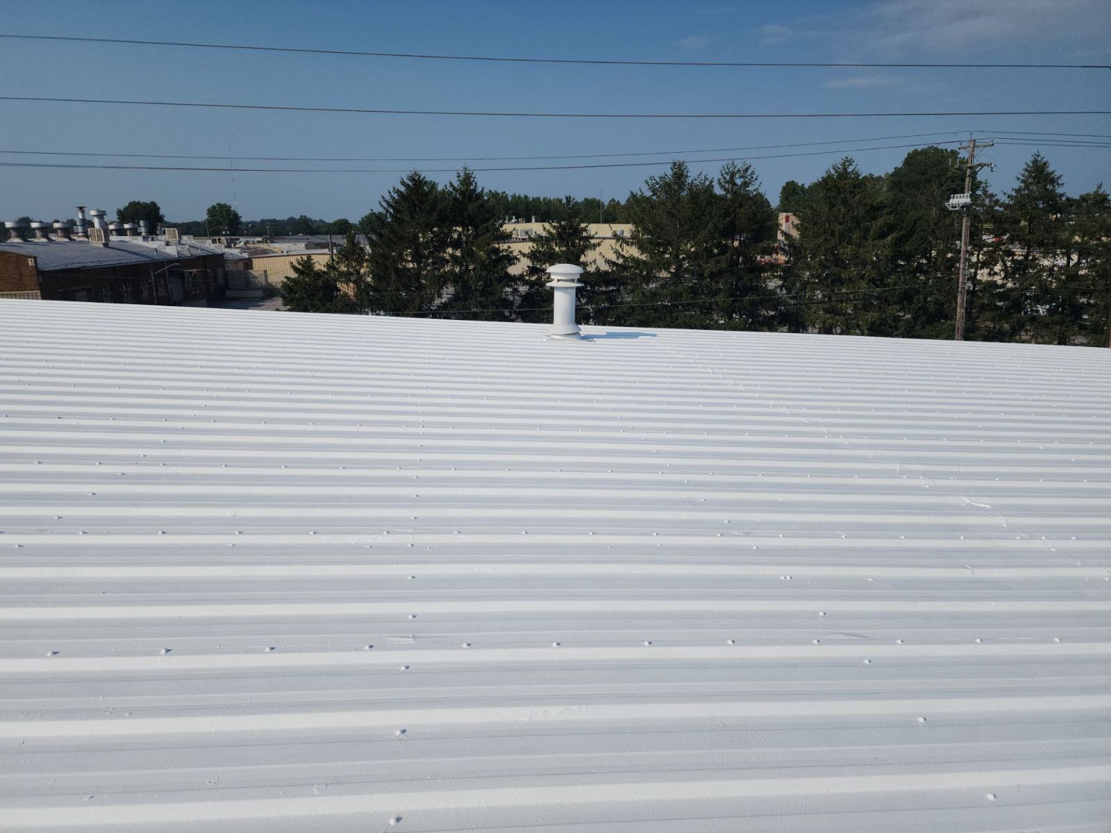 Coated metal roof with a sealed roof vent