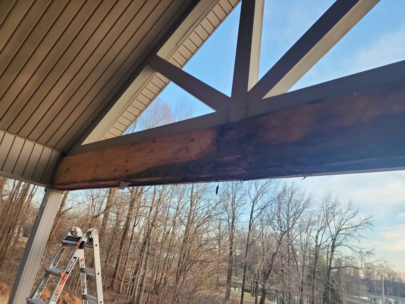 Rotted porch beam under a gable roof
